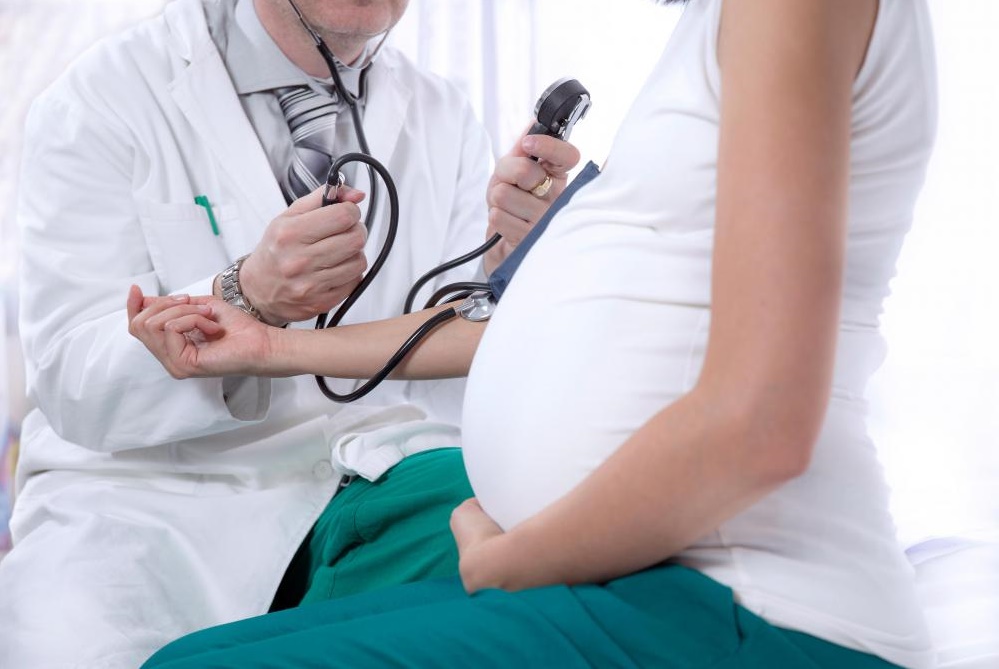 pregnant-woman-getting-blood-pressure-taken-by-doctor