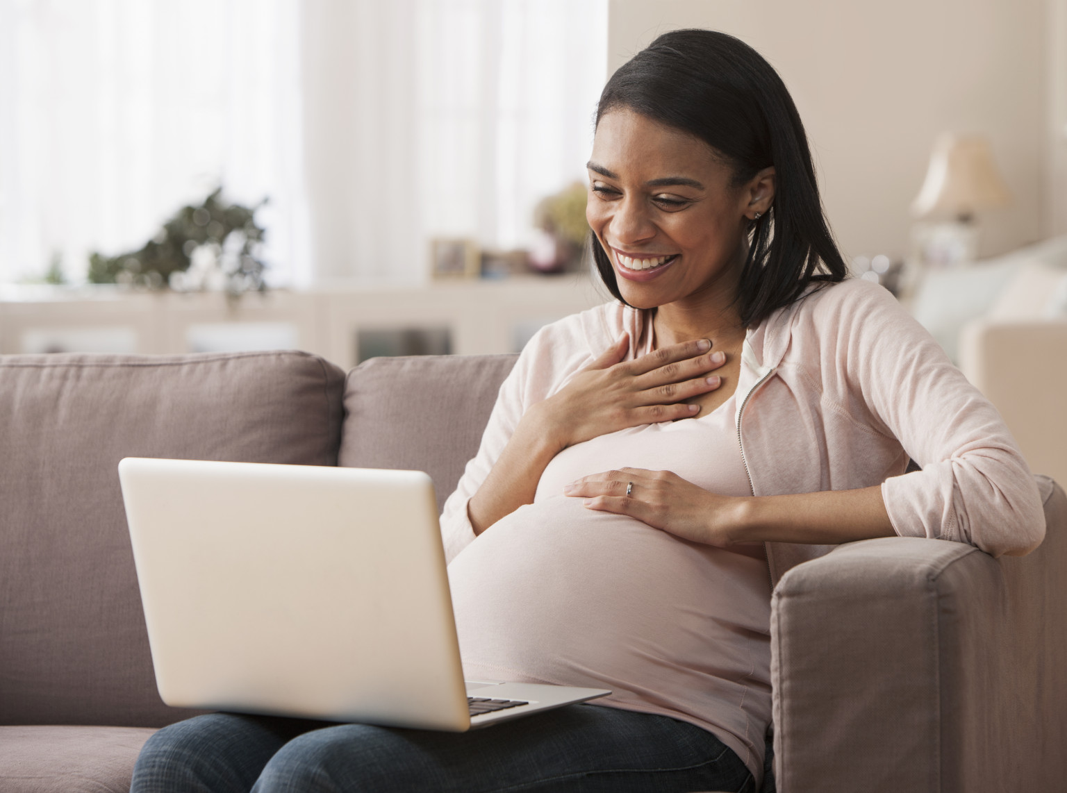 Pregnant woman sitting on laptop